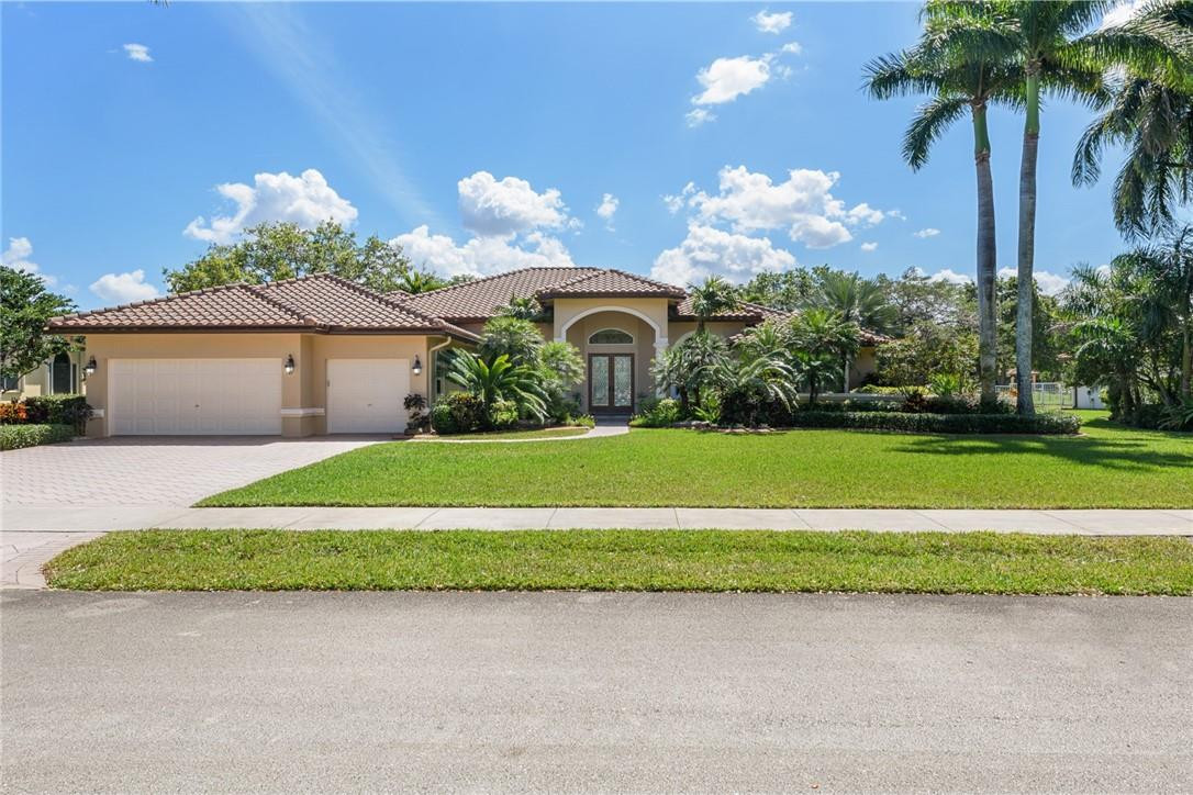 10324 Southwest 26th Street Davie, FL 33324 - Photo 2 of 37 a front view of a house with a garden and entryway
