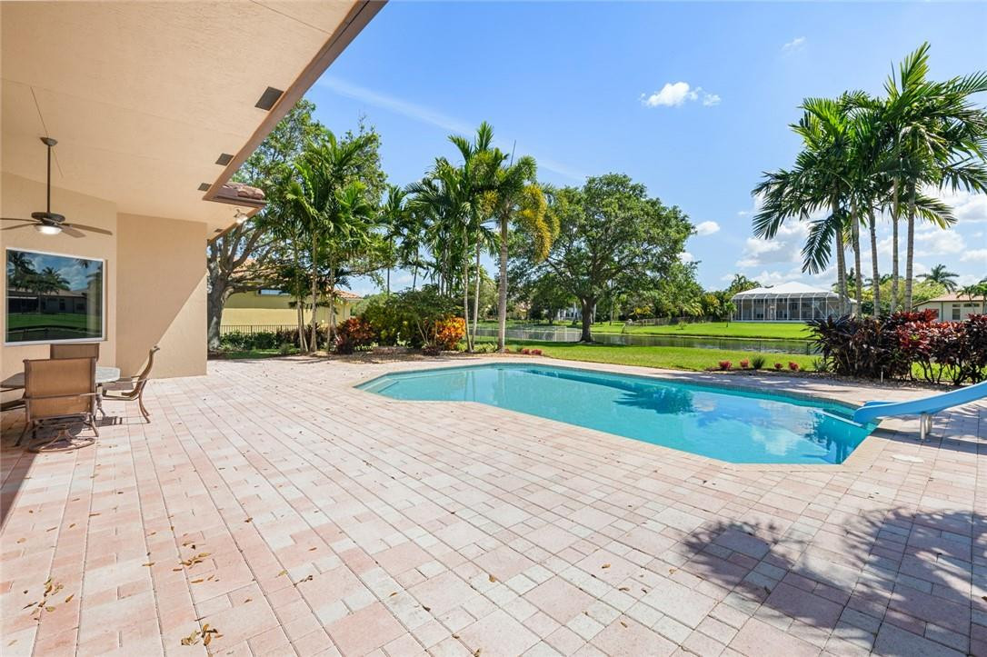 10324 Southwest 26th Street Davie, FL 33324 - Photo 30 of 37 a view of a swimming pool with a yard and palm trees