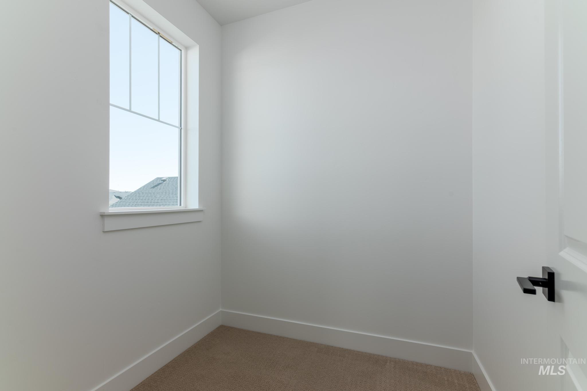14703 Serenity Pt Street Caldwell, ID 83607 - Photo 31 of 45 Bright interior space featuring a multi-pane window, neutral carpet flooring, crisp white walls, and white baseboards