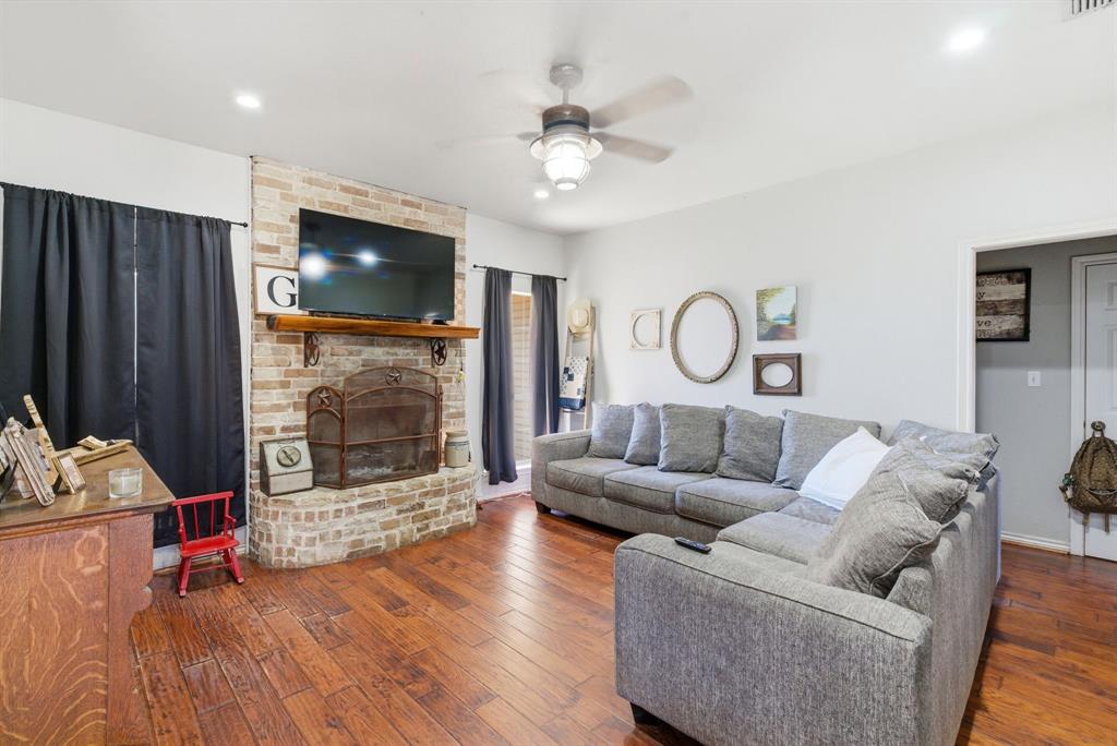 1889 Greenwood Road, Unit RES Weatherford, TX 76088 - Photo 3 of 11 a living room with furniture a fireplace and a flat screen tv