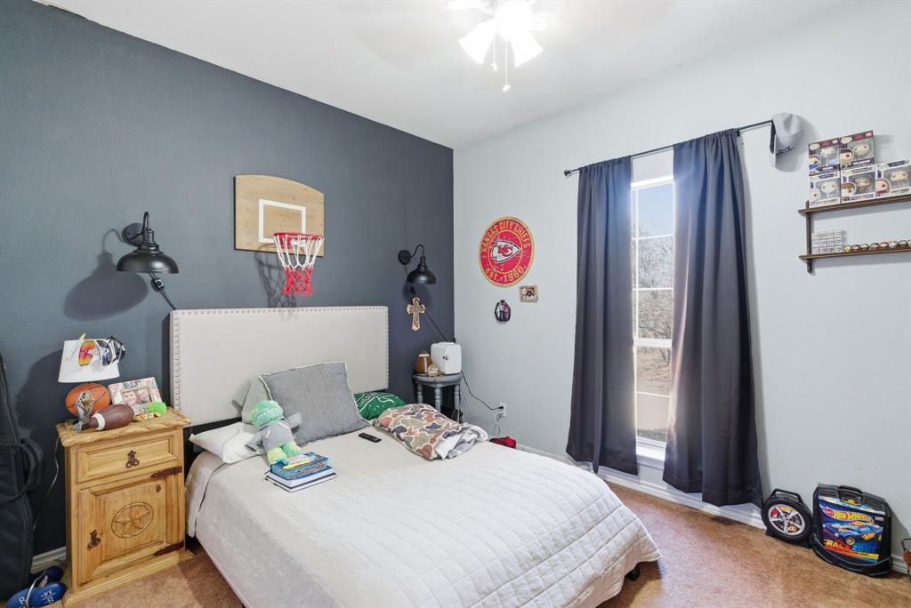 1889 Greenwood Road, Unit RES Weatherford, TX 76088 - Photo 6 of 11 a bedroom with a bed and a dresser