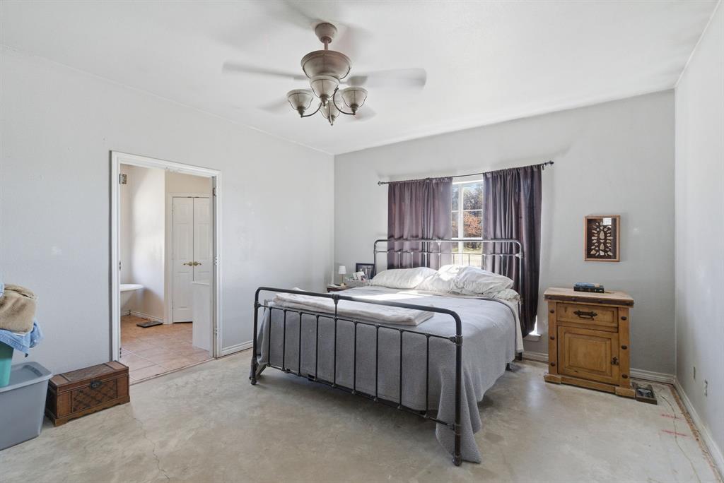 1889 Greenwood Road, Unit RES Weatherford, TX 76088 - Photo 8 of 11 a bed room with a bed and a chandelier