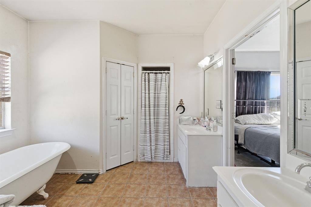 1889 Greenwood Road, Unit RES Weatherford, TX 76088 - Photo 10 of 11 a bathroom with a tub sink and mirror