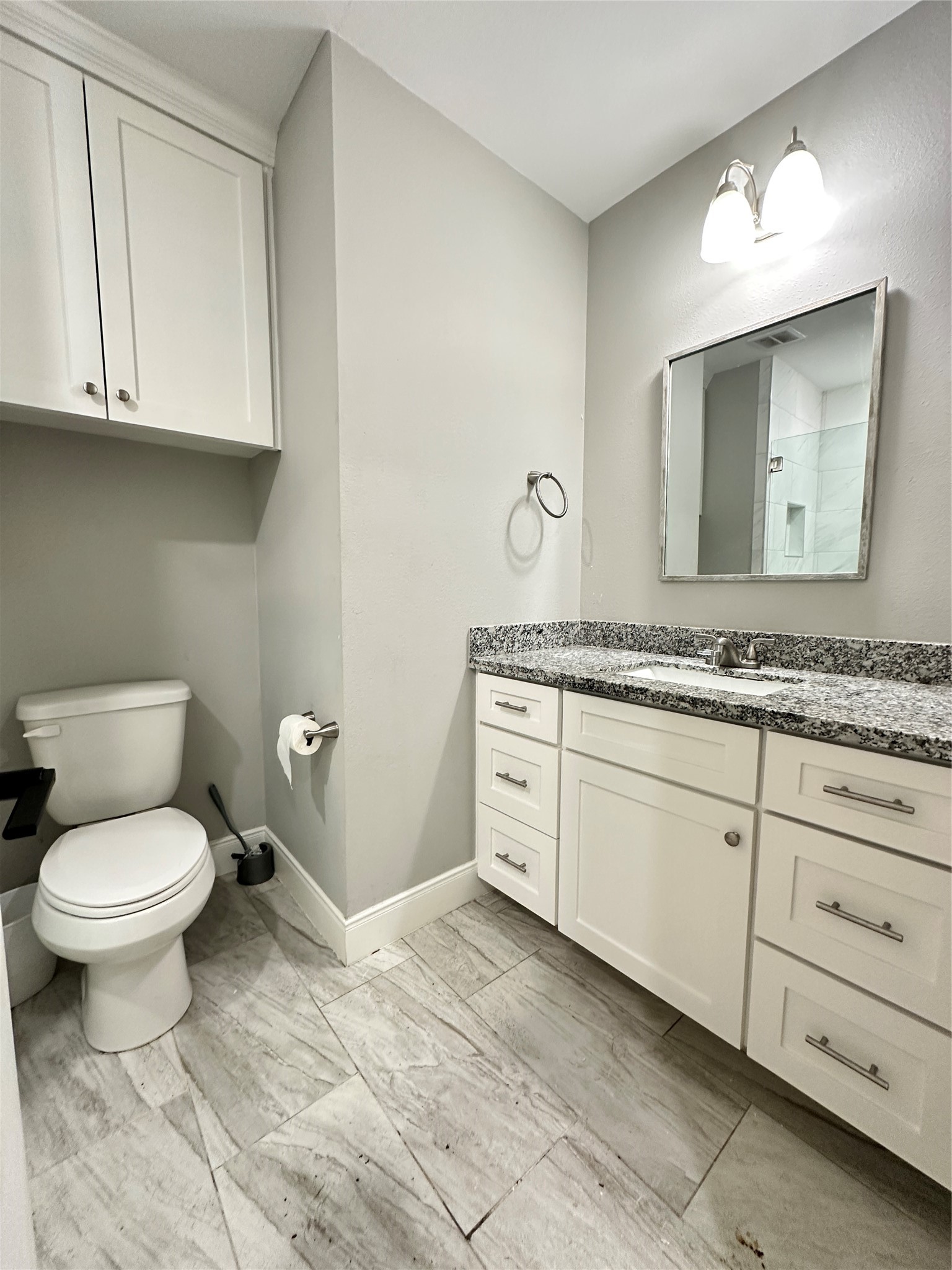 12703 West Hardy Road Houston, TX 77037 - Photo 15 of 29 a bathroom with a granite countertop toilet sink and mirror