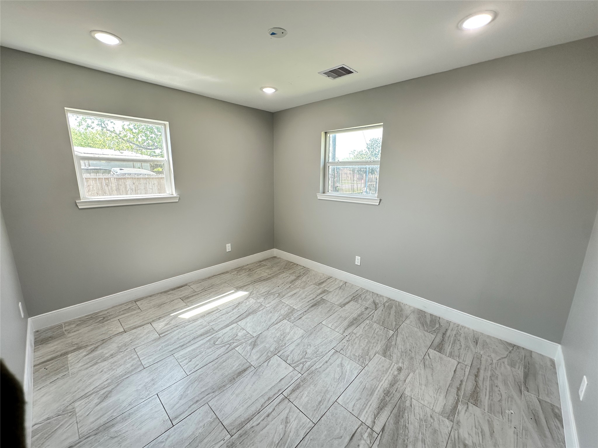 12703 West Hardy Road Houston, TX 77037 - Photo 19 of 29 an empty room with wooden floor and windows