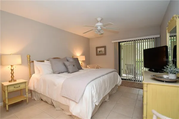 a bedroom with bed tv and a window