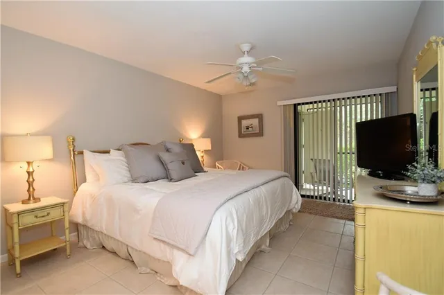 a bedroom with bed tv and a window