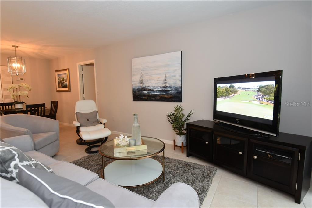 1667 Brookhouse Circle, Unit BR128 Sarasota, FL 34231 - Photo 6 of 38 a living room with furniture and a flat screen tv