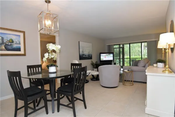 a dining room with furniture a chandelier and window