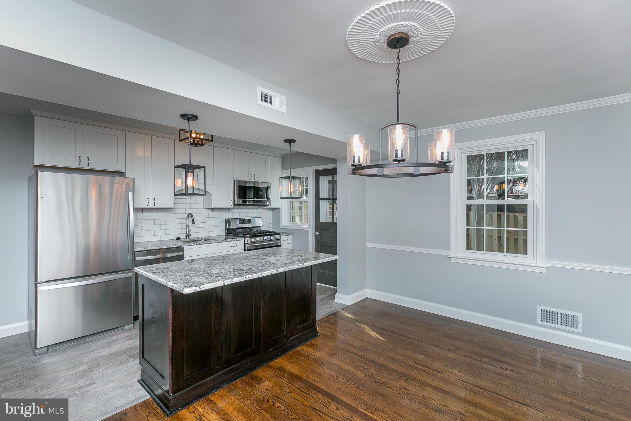 7126 Heathfield Road Baltimore, MD 21212 - Photo 1 of 23 a kitchen with kitchen island granite countertop stainless steel appliances a sink and a refrigerator