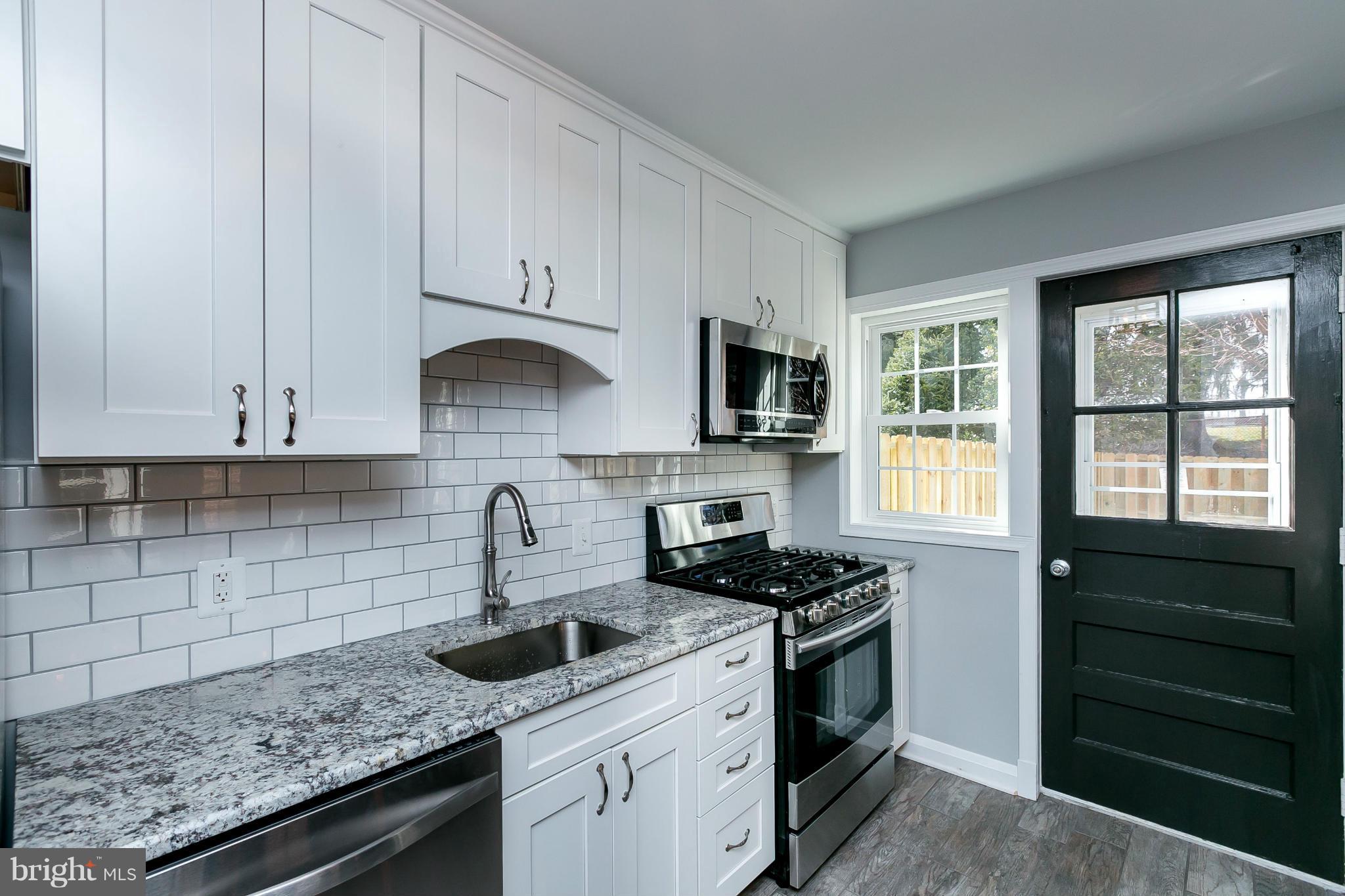 7126 Heathfield Road Baltimore, MD 21212 - Photo 3 of 23 a kitchen with granite countertop a sink a stove and cabinets
