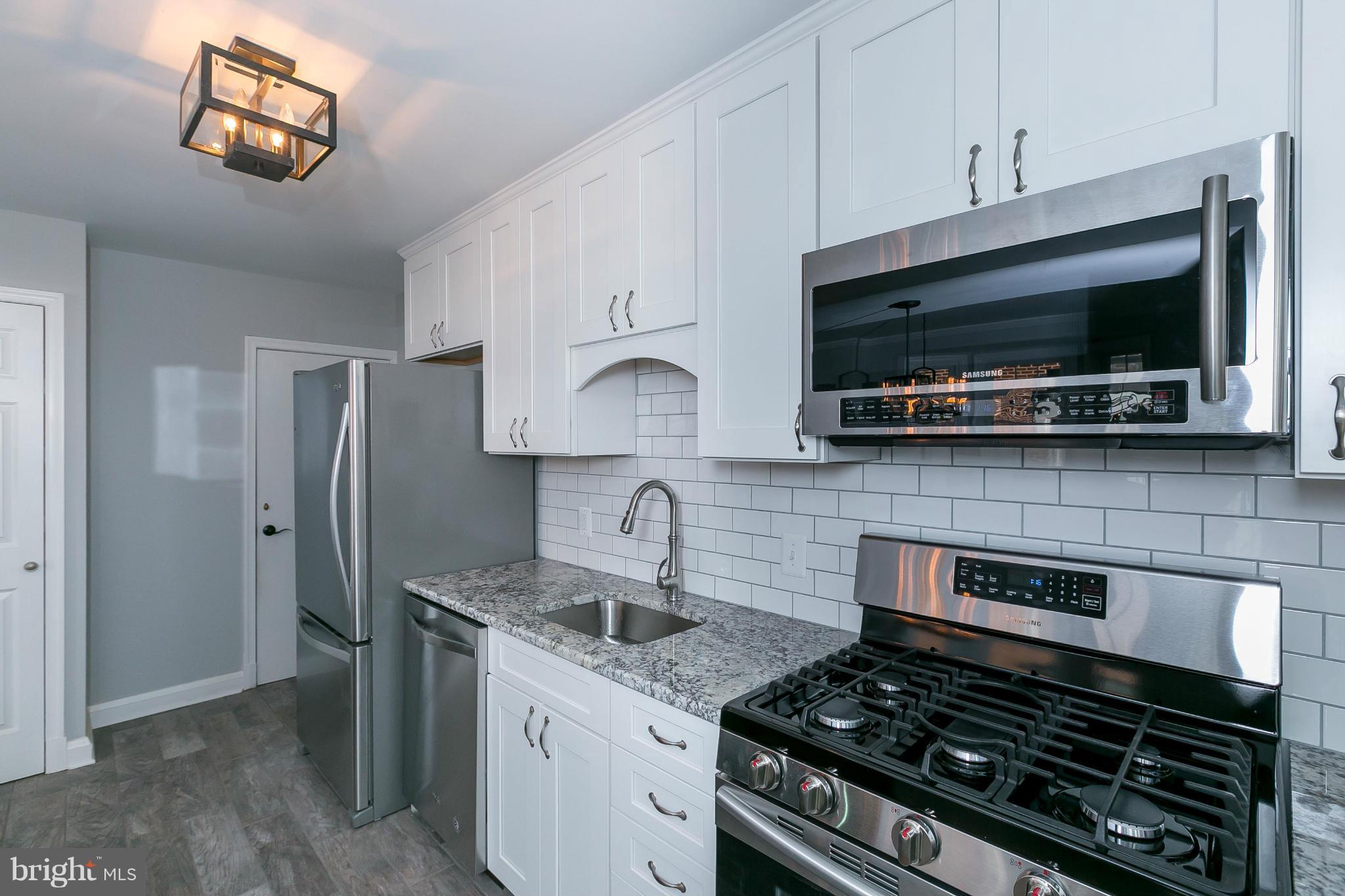 7126 Heathfield Road Baltimore, MD 21212 - Photo 4 of 23 a kitchen with stainless steel appliances granite countertop a stove and a microwave