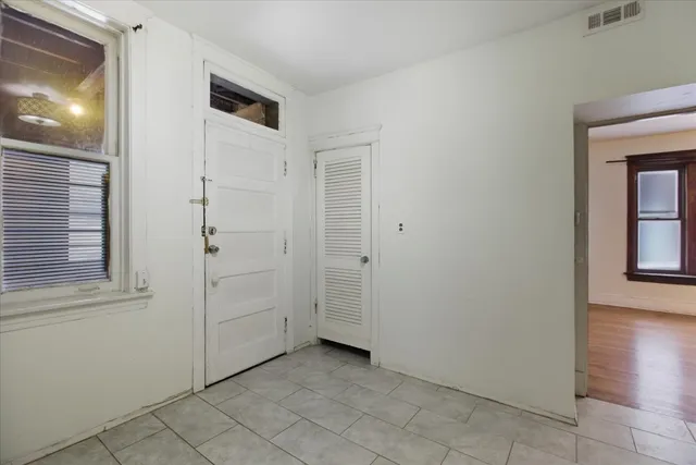 a view of a hallway with closet and a window