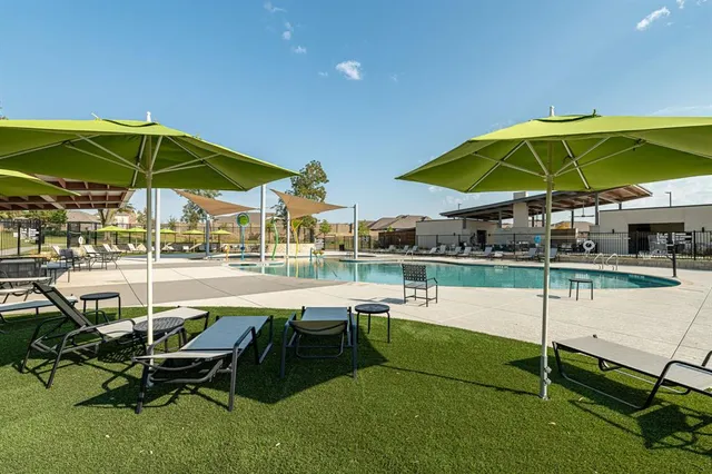 a view of a swimming pool with a table and chairs under an umbrella