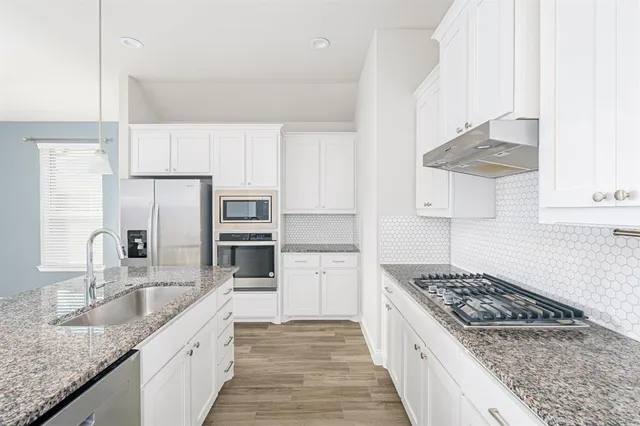 a kitchen with stainless steel appliances granite countertop a sink stove and refrigerator