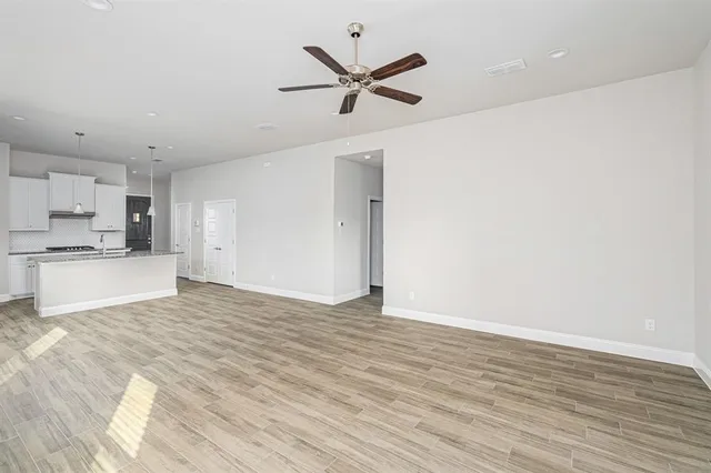 a view of a kitchen with a sink and dishwasher with wooden floor