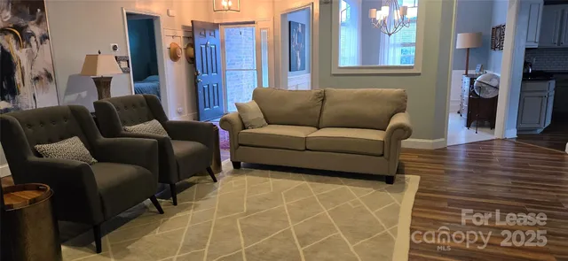 a living room with furniture a large window and a wooden floor