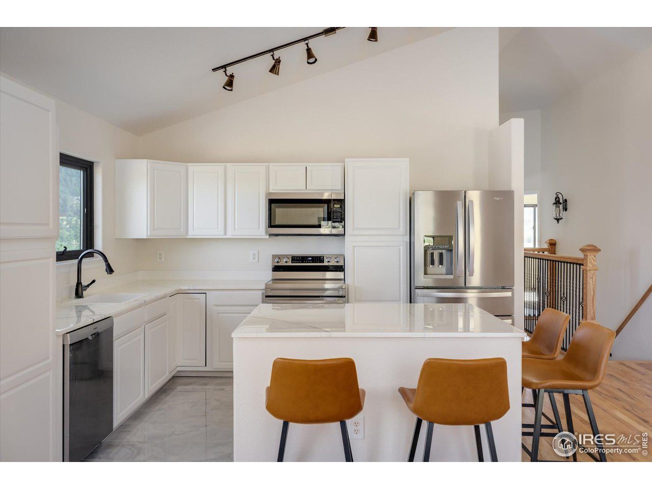 147 Makah Lane Lyons, CO 80540 - Photo 8 of 39 a kitchen with stainless steel appliances kitchen island granite countertop a dining table chairs and a refrigerator