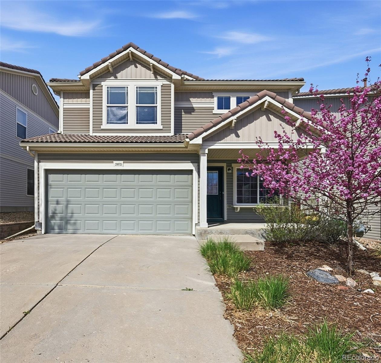 a front view of a house with yard and parking