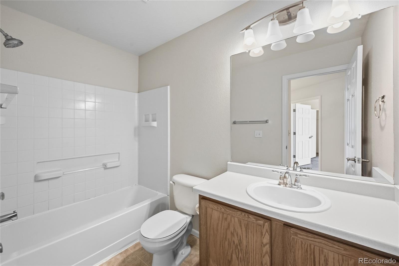 2075 Quartz Street Castle Rock, CO 80109 - Photo 19 of 25 a bathroom with a sink a toilet and a large mirror