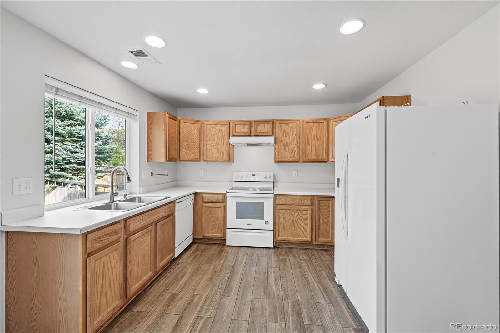 2075 Quartz Street Castle Rock, CO 80109 - Photo 9 of 25 a kitchen with stainless steel appliances granite countertop a stove a sink and white cabinets with wooden floor