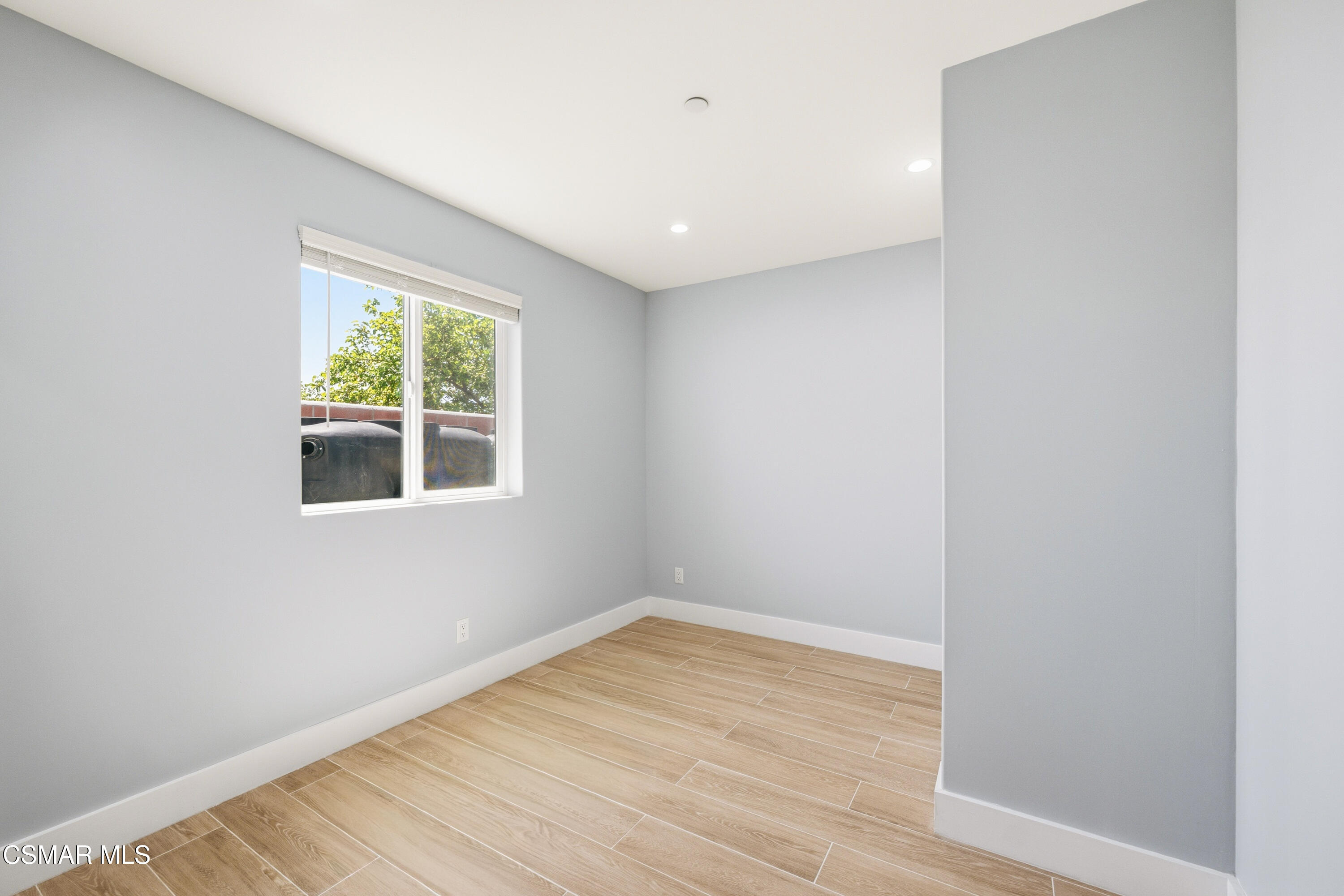 13102 Filmore Street Pacoima, CA 91331 - Photo 13 of 15 a view of empty room with wooden floor and fan