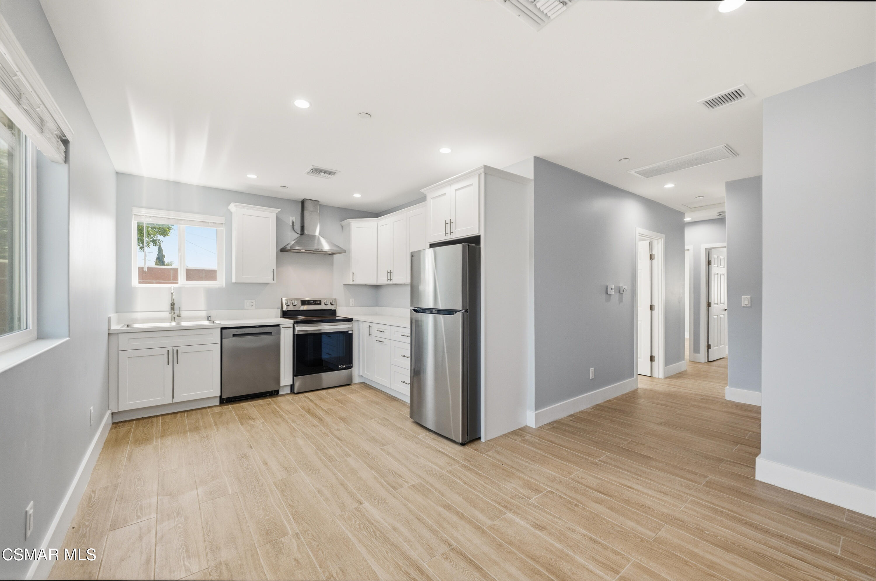 13102 Filmore Street Pacoima, CA 91331 - Photo 3 of 15 a kitchen with a refrigerator a sink and cabinets