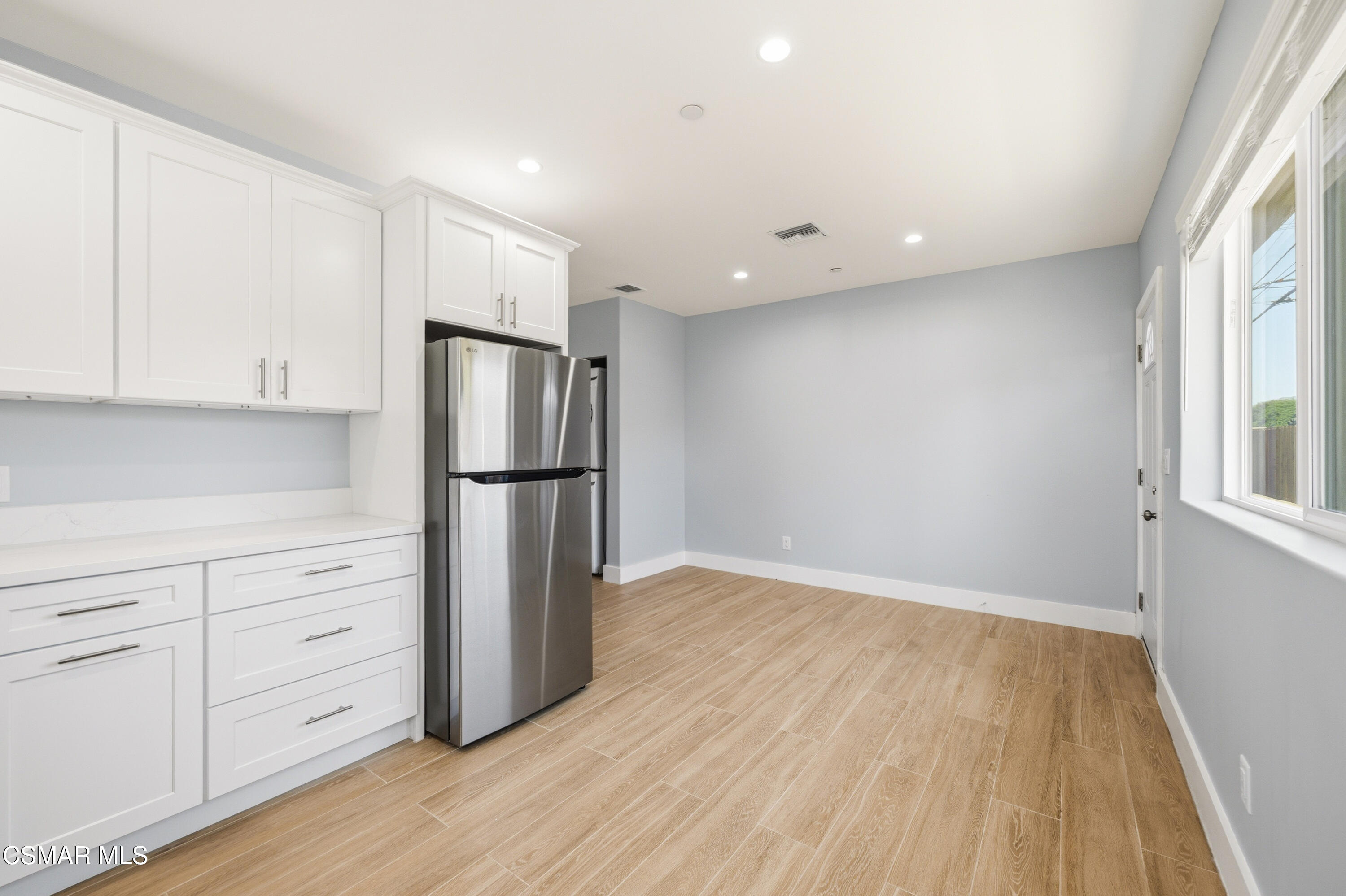 13102 Filmore Street Pacoima, CA 91331 - Photo 4 of 15 a kitchen with granite countertop white cabinets and stainless steel appliances