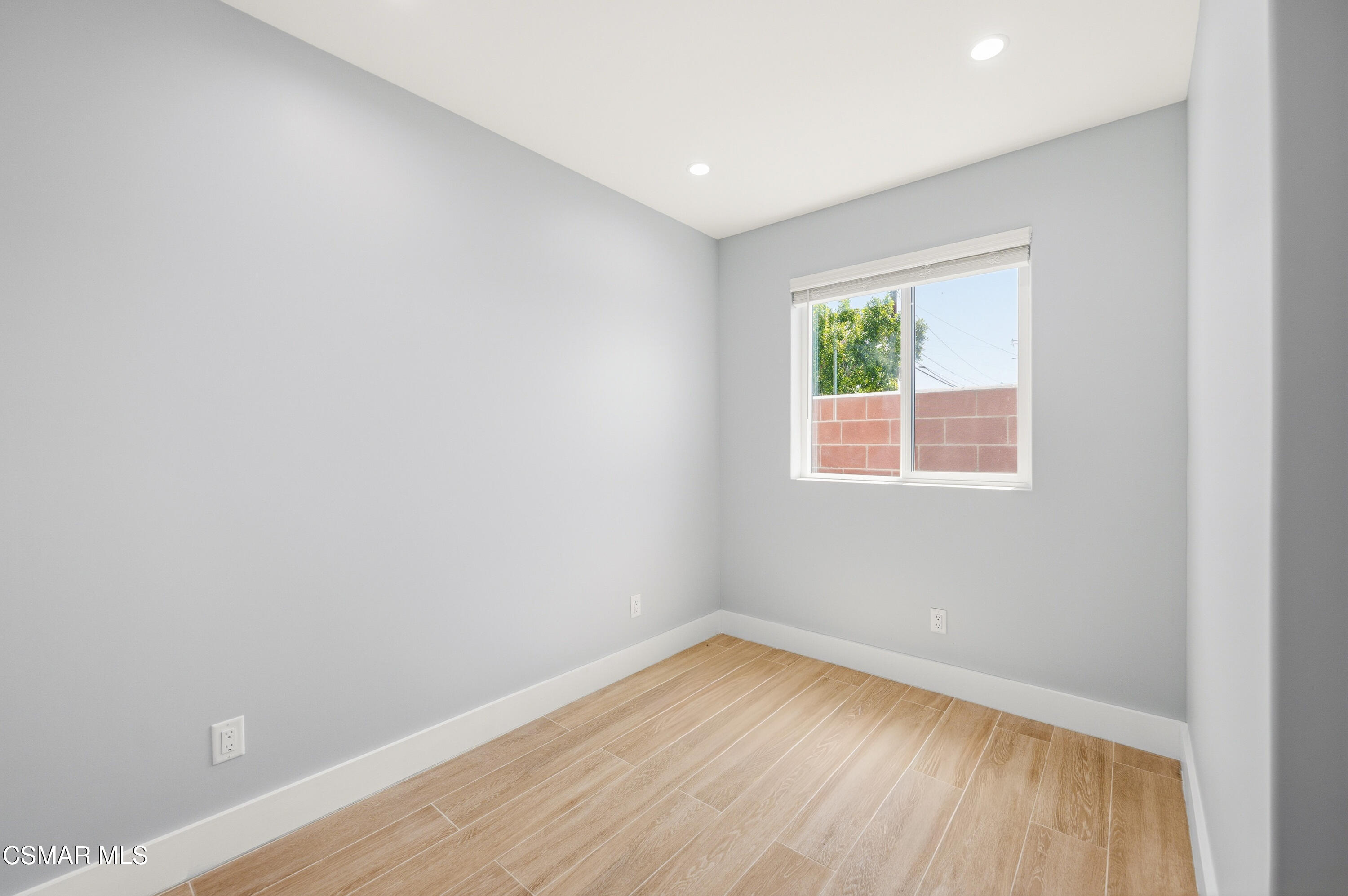 13102 Filmore Street Pacoima, CA 91331 - Photo 8 of 15 an empty room with wooden floor and windows