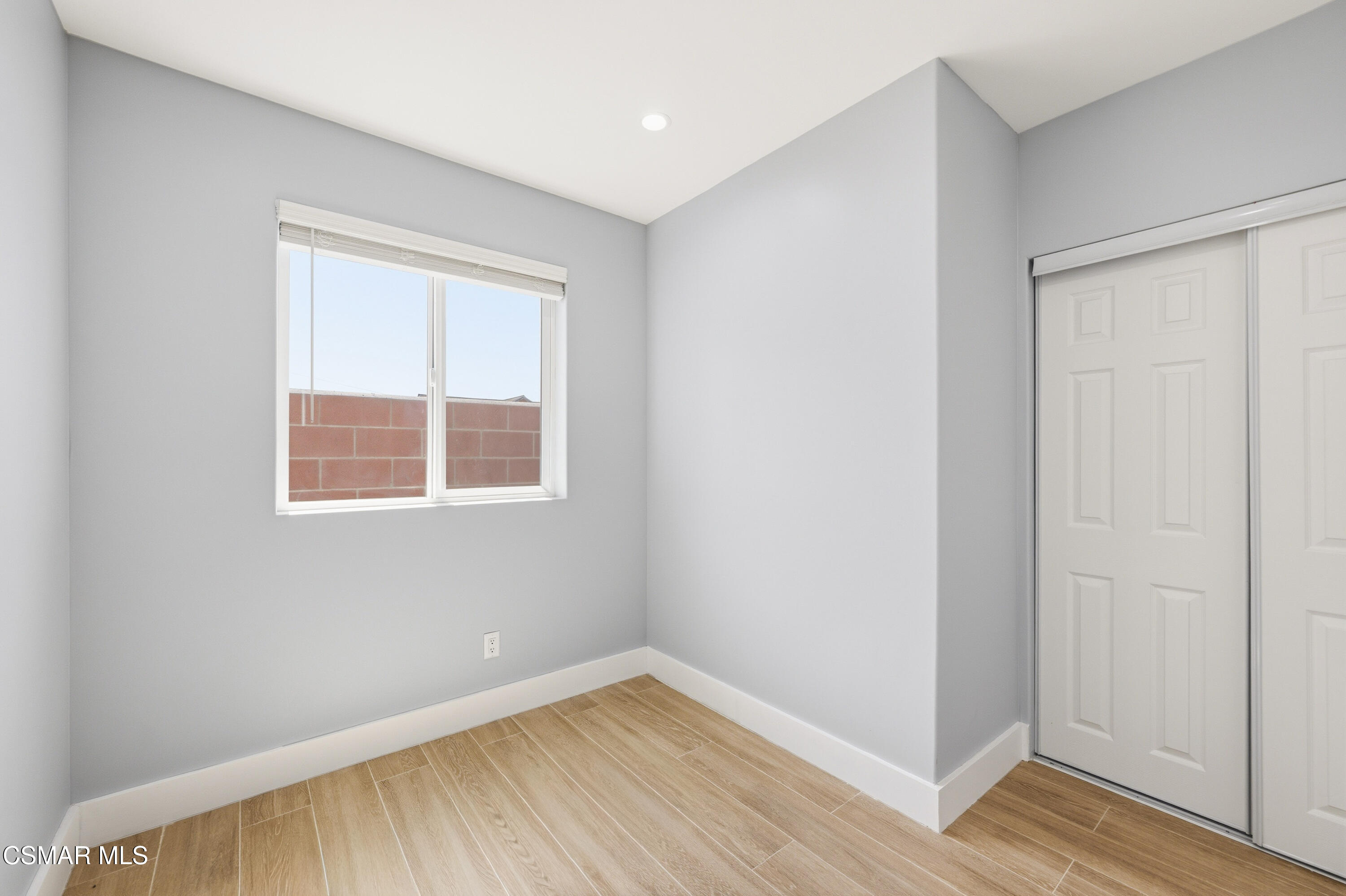 13102 Filmore Street Pacoima, CA 91331 - Photo 9 of 15 an empty room with wooden floor and windows