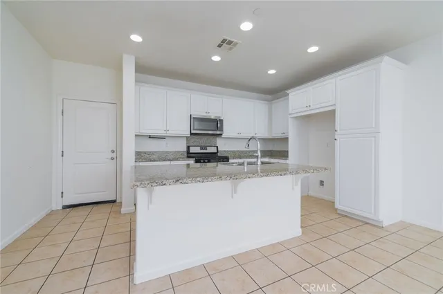 a kitchen with stainless steel appliances a refrigerator sink and cabinets