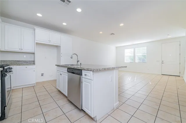 a kitchen with a sink a stove and white cabinets