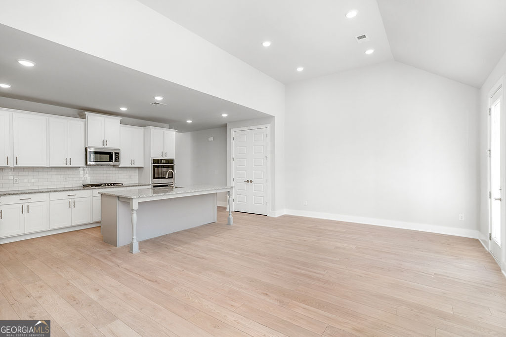 2604 Parkside Way Gainesville, GA 30507 - Photo 15 of 33 a large kitchen with stainless steel appliances a large counter top and wooden floors