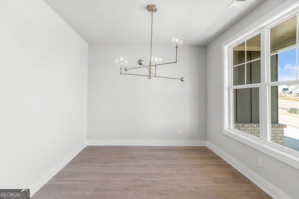 2604 Parkside Way Gainesville, GA 30507 - Photo 7 of 33 an empty room with wooden floor and windows