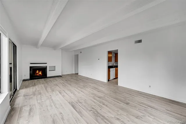 a view of empty room with wooden floor