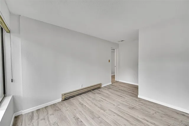 a view of an empty room with wooden floor