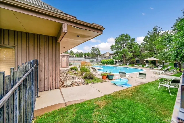 a view of backyard with swimming pool and sitting area