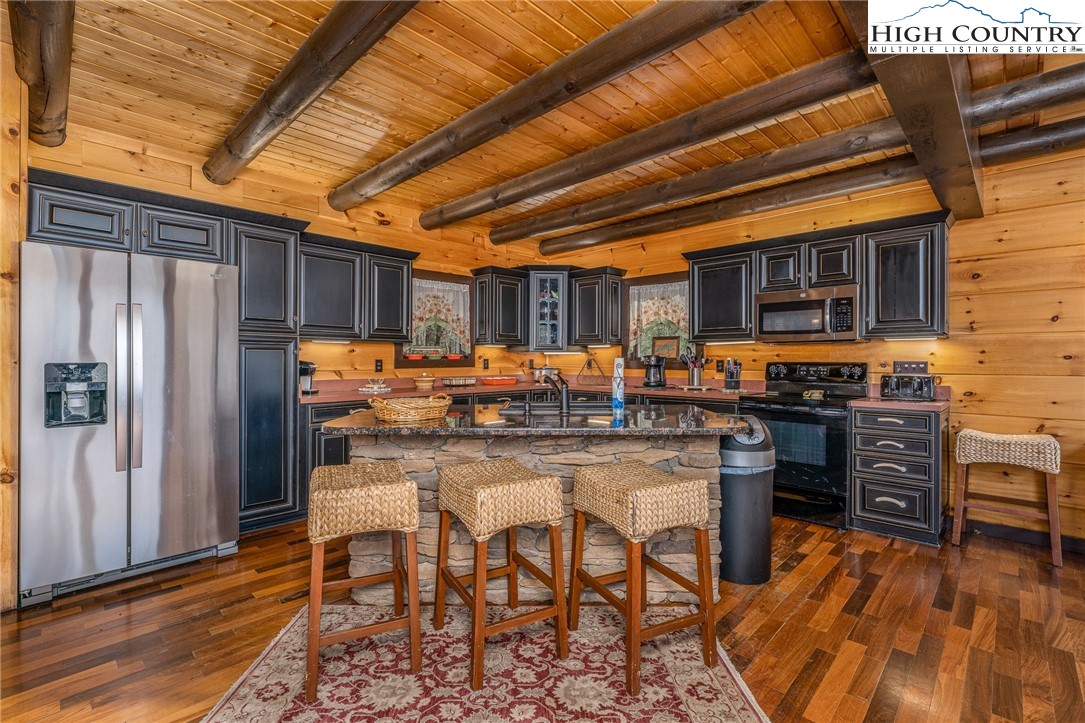 502 Poga Road Butler, TN 37640 - Photo 19 of 50 a kitchen with stainless steel appliances granite countertop a refrigerator and wooden cabinets