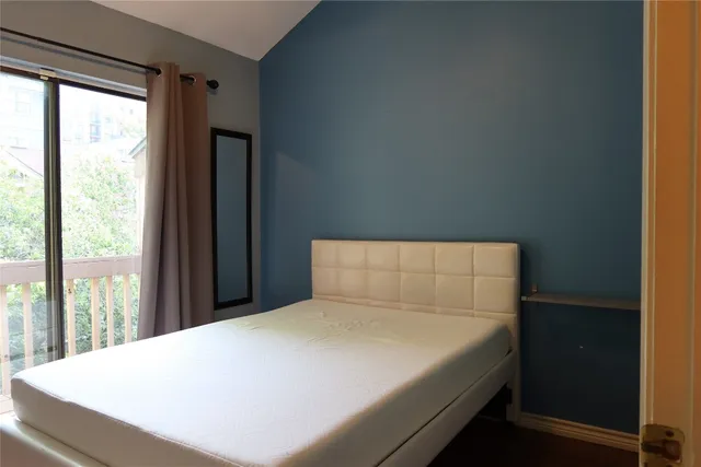 a bed sitting in a bedroom next to a window