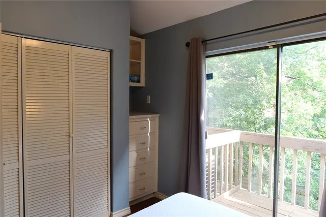 a bedroom with a balcony a bed and a window