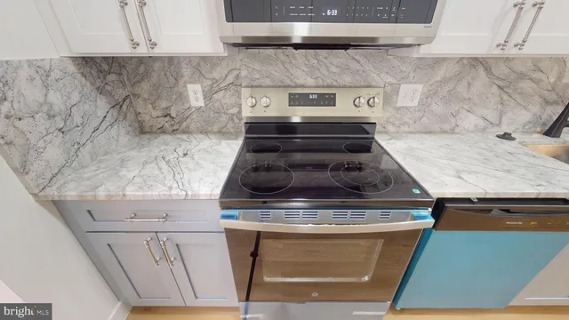 a stove top oven sitting inside of a kitchen