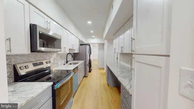 a kitchen with stainless steel appliances granite countertop a refrigerator a stove top oven a sink and dishwasher