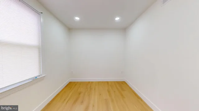 a view of empty room with wooden floor