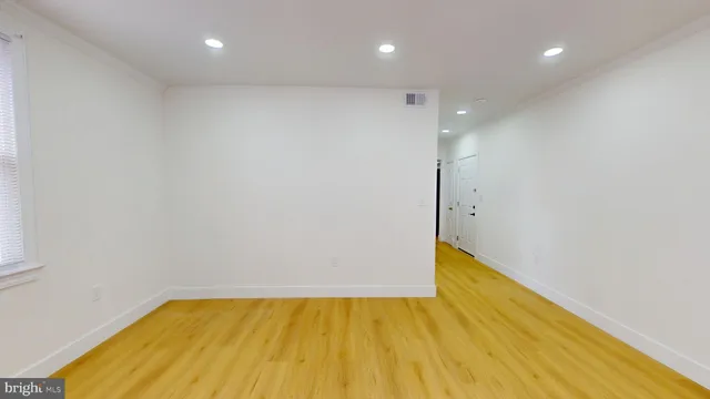 a view of an empty room with wooden floor