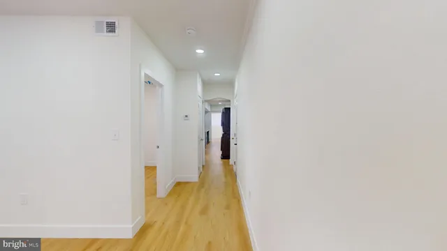 a view of a hallway with wooden floor
