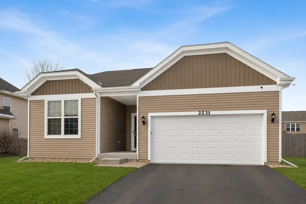 a front view of a house with a yard and garage