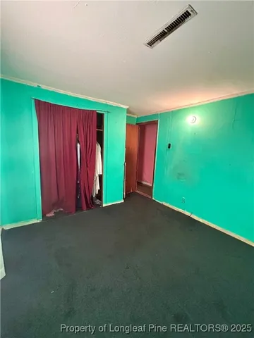 a view of an empty room with window and stairs