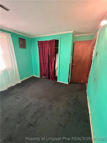 a view of an empty room with window and stairs