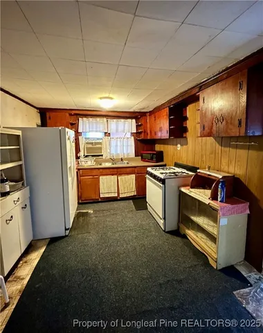 a open kitchen with stainless steel appliances granite countertop a refrigerator a stove top oven a sink and dishwasher