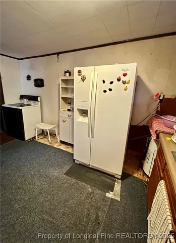 a view of storage and utility room with a refrigerator